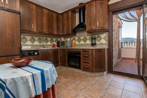 a kitchen with wooden cabinets and a table in it at Mirador de El Yelmo in El Ojuelo