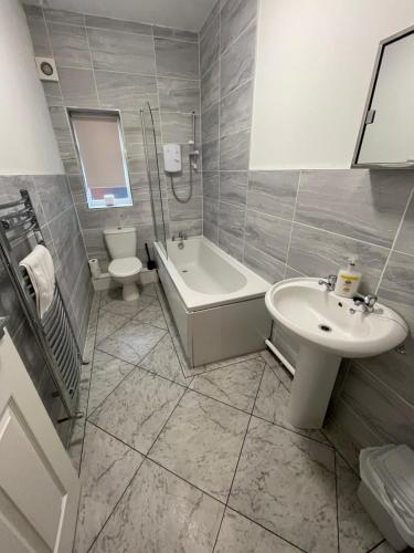 a bathroom with a sink and a tub and a toilet at Hosted By Ryan - 2 Bedroom House in Liverpool