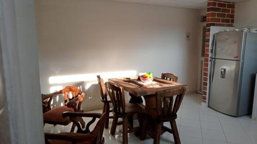 cocina con mesa de madera con sillas y nevera en Apartamento Amoblado en Ibagué, en Ibagué