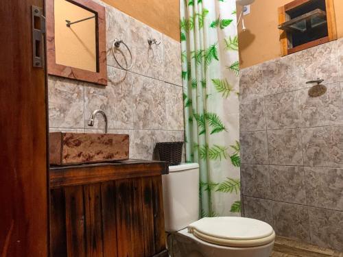 y baño con aseo y lavamanos. en Pousada Aconchego - Suítes Rústicas e Privativas, en Lençóis