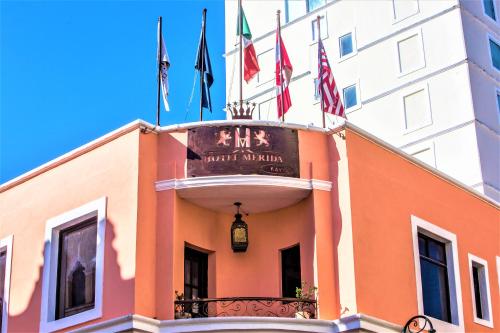 a building with flags on top of it at Hotel Merida in Mérida