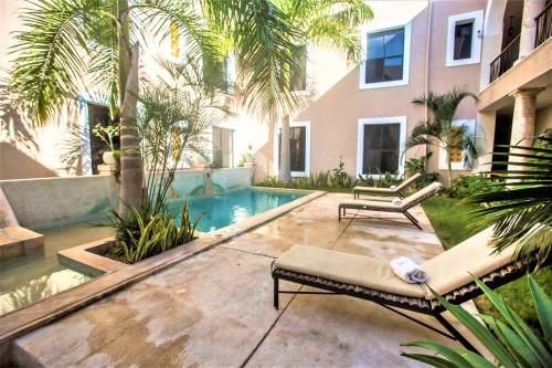 a backyard with a swimming pool and a house at Hotel Merida in Mérida