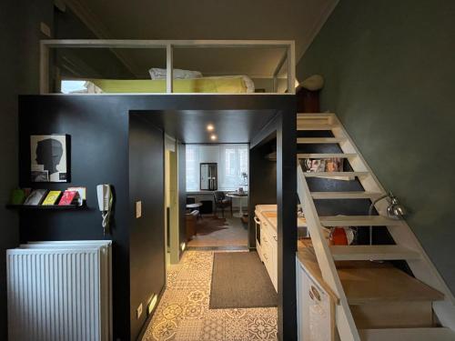 een kleine kamer met een stapelbed en een trap bij Studio Dageraad in Antwerpen