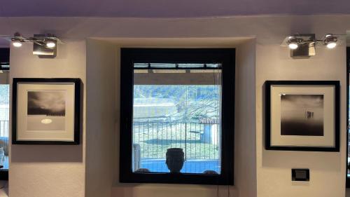 a wall with two framed pictures and a window at Cameloth B&B in Settimo Rottaro