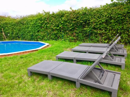 a group of lounge chairs and a swimming pool at Yourte mongole in Huriel