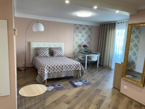 1 dormitorio con cama, mesa y espejo en Studio With Swimming Pool 80 meters near the beach en Niza