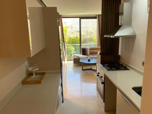 a kitchen with a stove and a living room at Très beau studio à Ain Diab in Casablanca