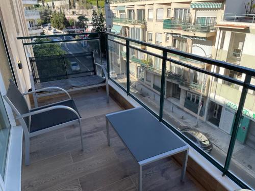 a balcony with a blue table and chairs on a building at Studio With Swimming Pool 80 meters near the beach in Nice