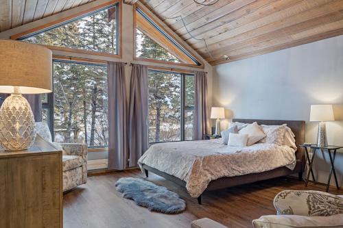 a bedroom with a bed and large windows at Canmore Cabin by Canadian Rockies Vacation Rentals in Canmore