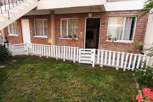 una cerca blanca frente a una casa en 7 GIRASOLES a 4 cuadras del mar en Puerto Madryn