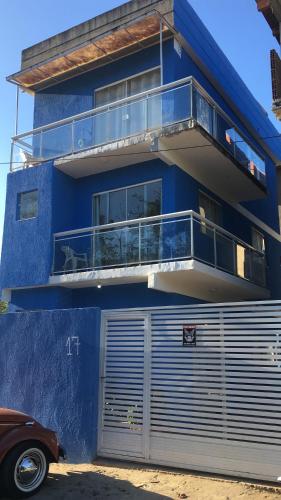 a blue building with a balcony and a garage at Triplex Costazul Temporada in Rio das Ostras