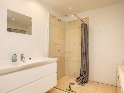 baño blanco con ducha y lavamanos en Two-Bedroom Holiday home in Hals 17, en Hals