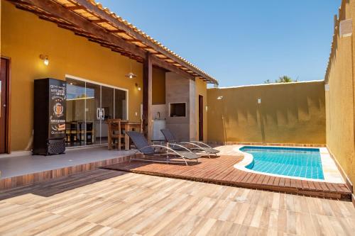 un patio trasero con piscina y una casa en Casa com Piscina Armação de Búzios, en Búzios