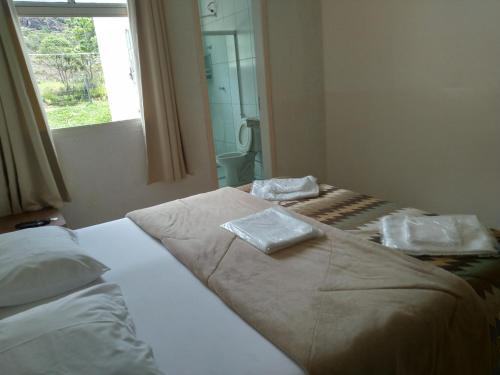 una camera da letto con un letto con due asciugamani sopra di POUSADA VILA DO BIRIBIRI EXCLUSIVAMENTE DENTRO da VILA DO BIRIBIRI a Diamantina