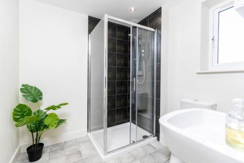 een badkamer met een douche en een wit bad bij Avery House 1 - One Bedroom with Outdoor Terrace in Darlington