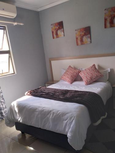 sypialnia z łóżkiem z czerwonymi poduszkami w obiekcie Legugu Bed and Breakfast w mieście Nongoma