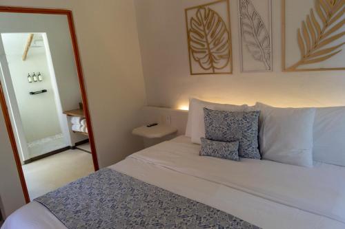 a bedroom with a bed with two pillows and a mirror at Hotel Circulo Bacalar in Bacalar