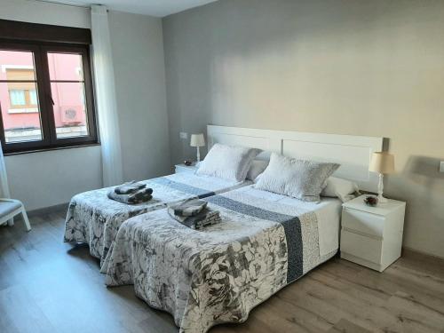 - une chambre blanche avec un grand lit et une couverture dans l'établissement La Casa de Maricruz, à Cangas de Onís