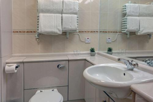 a white bathroom with a sink and a toilet at Woodlands Hotel, BW Signature Collection in Dundee