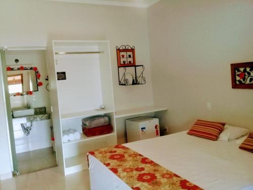 a bedroom with a bed and a room with a window at Hotel Pousada Riacho da Areia in Águas de Lindóia