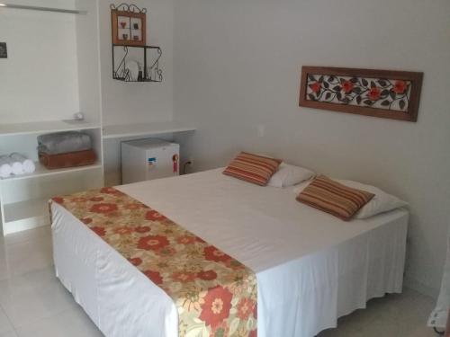 a bedroom with a large white bed in a room at Hotel Pousada Riacho da Areia in Águas de Lindóia