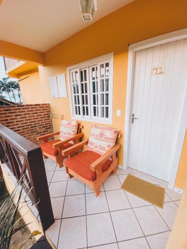 a porch with two chairs and a door at Pousada Porto Girassol in Abraão