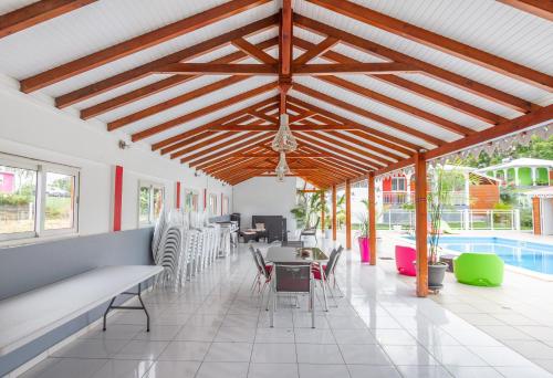 a restaurant with tables and chairs and a pool at Les Villas de Boisvin in Le Moule