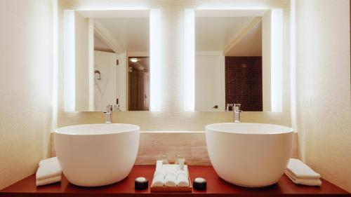 a bathroom with two sinks and a large mirror at Nobu Las Vegas, A Caesars Destination in Las Vegas
