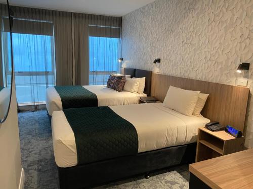 a hotel room with two beds and a desk at Trinity Hotel in Wellington