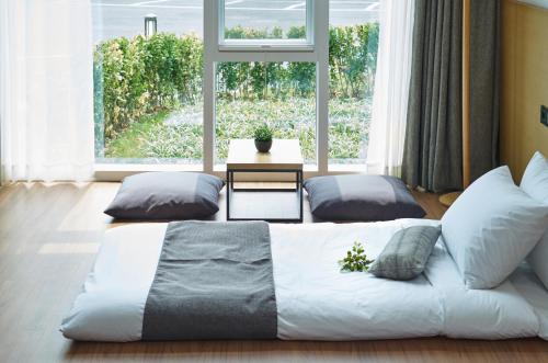 a large bed in a room with a large window at Naksan Beach Hotel in Yangyang