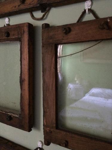 a mirror hanging on a wall next to a bed at La Casa di Marla in Sirmione