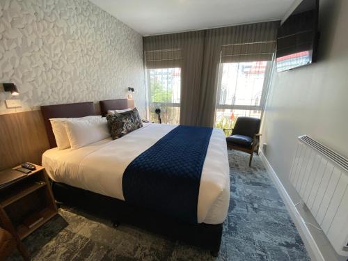 a hotel room with a large bed and a window at Trinity Hotel in Wellington
