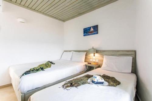 two beds sitting next to each other in a room at Meltemi apartment by opus in Agios Stefanos