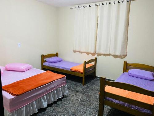 une chambre avec deux lits et une fenêtre dans l'établissement Chácara Cateto, à Socorro