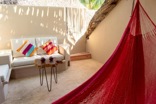 a living room with a red hammock in a room at Hotel Circulo Bacalar in Bacalar