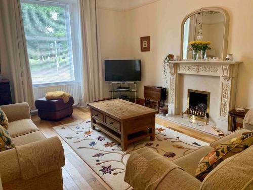 a living room with a couch and a fireplace at Allerton - Victorian Character Home in Stirling in Stirling
