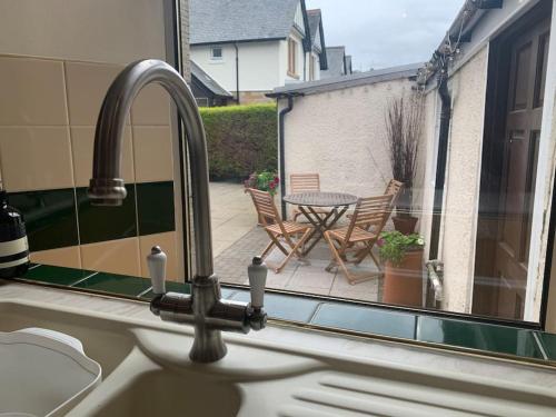 スターリングにあるAllerton - Victorian Character Home in Stirlingのテーブルのあるパティオが見えるキッチンシンク