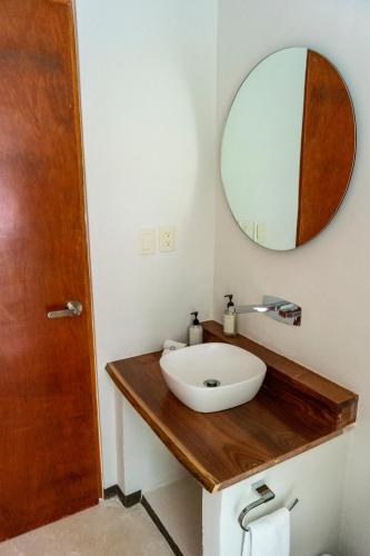 a bathroom with a white sink and a mirror at Hotel Circulo Bacalar in Bacalar