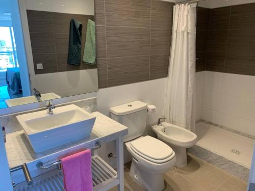 ein Badezimmer mit einem Waschbecken, einem WC und einer Badewanne in der Unterkunft Apartamento 901 torre One II in Punta del Este