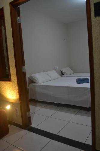 1 dormitorio con cama y espejo en Chácara de Serra! en Tianguá