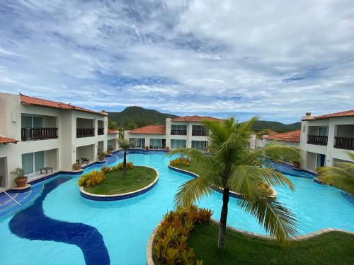 an aerial view of a resort swimming pool with a palm tree at Buzios Beach Resort Super Luxo Residencial 2501 e 2502 in Búzios