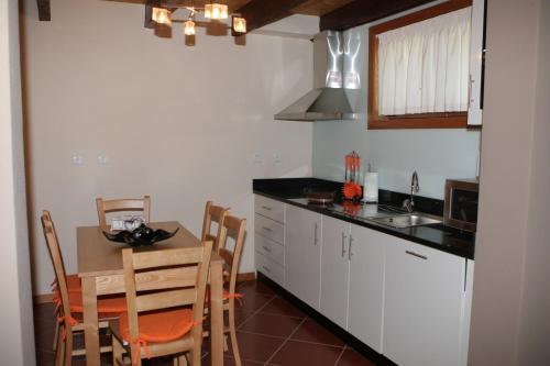 a kitchen with a table and a dining room at Casa do Olival in Macedo de Cavaleiros