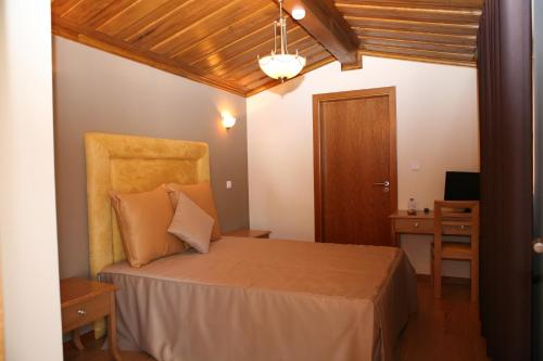 a bedroom with a bed with a chair and a desk at Casa do Olival in Macedo de Cavaleiros