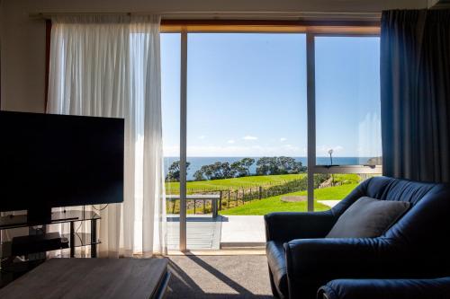a living room with a couch and a large window at Pacific Rendezvous Resort in Tutukaka