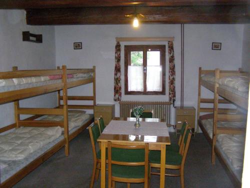 a room with a table and bunk beds at Chata U Jakuba in Prášily