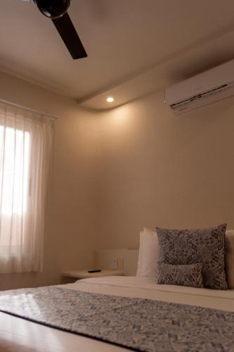 a bedroom with a bed with a ceiling fan at Hotel Circulo Bacalar in Bacalar