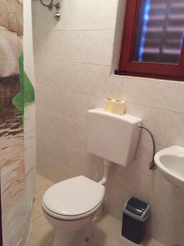 a bathroom with a white toilet and a sink at Apartment Luna in Lun