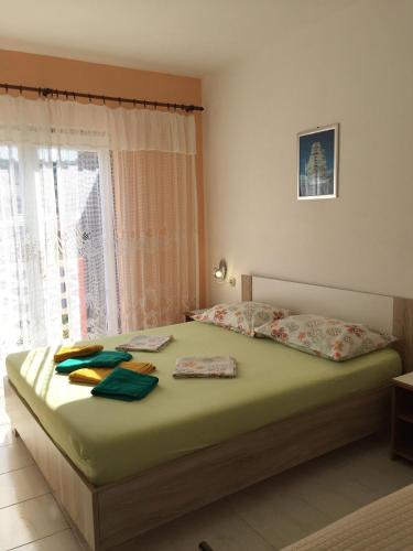 a bedroom with a bed with green sheets and a window at Apartment Luna in Lun