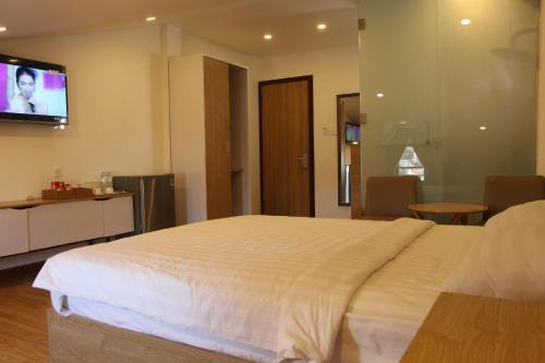 a bedroom with a large bed and a flat screen tv at An Gia in Da Lat