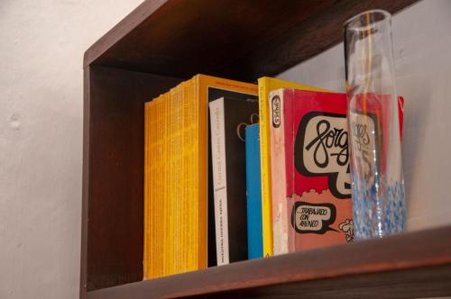 a wooden book shelf with books on it at La Juanita Hostel Barichara in Barichara
